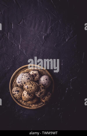 Small Quail Eggs on Dark Stone Background Stock Photo