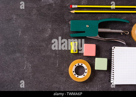 Assorted of school supplies on black slate. Back to school concept. Copyspace Stock Photo