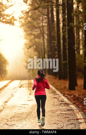 Athlete running on road in morning sunrise training for marathon and fitness. Healthy active lifestyle woman exercising outdoors. Stock Photo