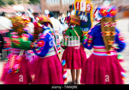 Manual zoom blur of Quechua indigenous people with traditional clothing during dances on Inti Raymi Sun Festival, Plaza de Armas, Cusco, Peru. Stock Photo