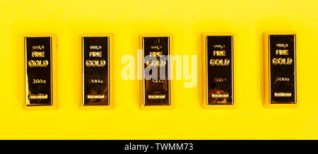 Bars of gold bullion on yellow background. Financial concept. Stock Photo