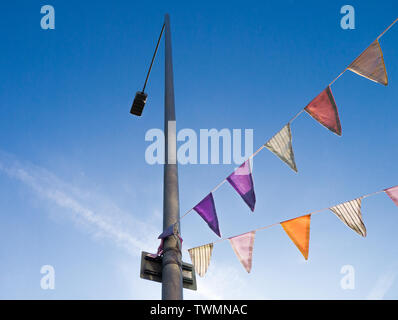 Colour image of bunting attached to a lamp post, shot from below against a blue sky Stock Photo