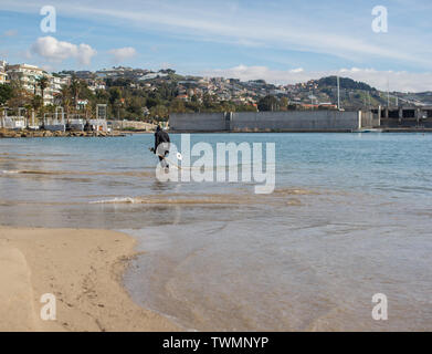 A man in a diving suit looking for coins metal detector at the bottom of the bay. Stock Photo