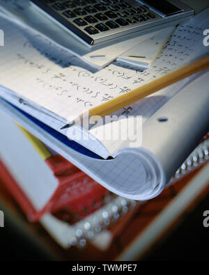 Selective focus image of school homework with notebook open to hand written math formulas Stock Photo