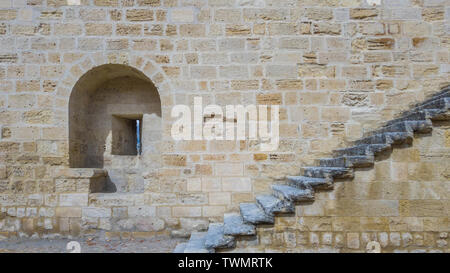 An embrasure and a staircase on the stone wall of an ancient fortress. Stock Photo