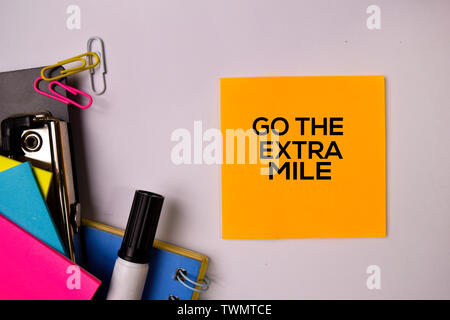 Go The Extra Mile on sticky notes isolated on white background. Stock Photo