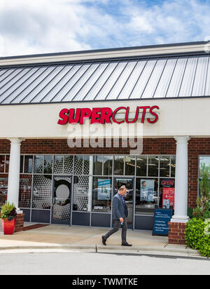 MOORESVILLE, NC, USA-JUNE 19, 2019: A local Supercuts Salon, with well-dressed man walking in front. This is one of more than 2400 locations in the U. Stock Photo