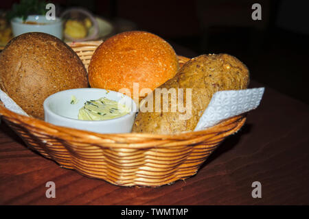 Delicious, freshly baked bread of various assortment in a straw basket. Stock Photo