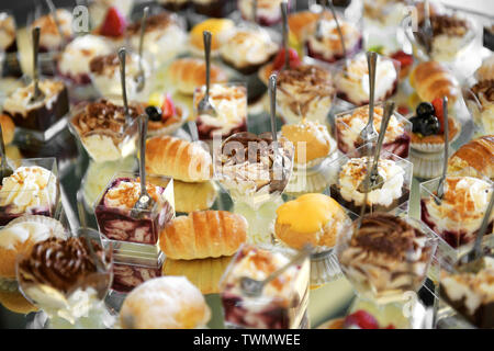 Large selection of freshly baked pastries for dessert displayed on a buffet at a hotel or restaurant in a full frame close up view Stock Photo