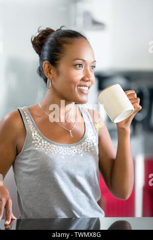 Happy woman holding a cup of coffee in her Indonesian woman making coffee Stock Photo