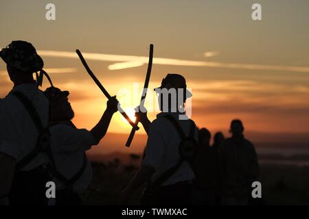 Gower, Swansea, Wales, UK. 21st June 2019. The Sweyn's Ey (correct) Morris Dancers celebrated the summer solstice as the sun set over the the neolithic tomb of Arthur's Stone on Cefn Bryn hill, Gower peninsula, south Wales. The 'Sweyn's Ey' Morris Dance side (correct term) derive their name from the widely believed Viking origins of the place name 'Swansea'. Credit: Gareth Llewelyn/Alamy Live News Stock Photo