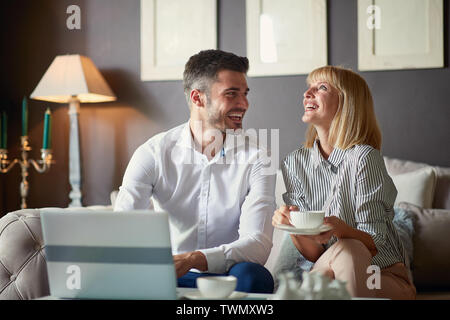 Satisfied business partners working on laptop with cup of coffee Stock Photo