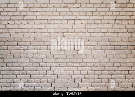 High resolution full frame background of detailed old pale brick wall with vignetting. Stock Photo