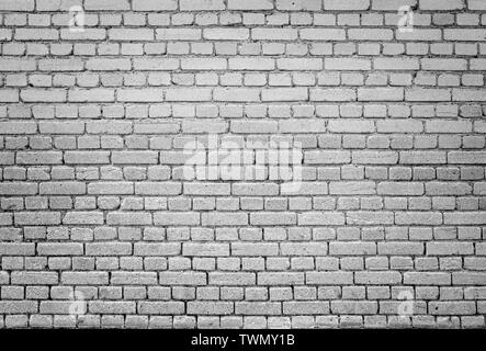 High resolution full frame background of detailed old brick wall in black and white with vignetting. Stock Photo