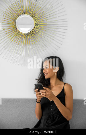 Woman Using His Mobile Phone During A Coffee Break In White Coworking Office Stock Photo