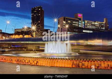 UK,South Yorkshire,Sheaf Square,Sheffield Railway Station Water Feature & City Centre Buildings at Night Stock Photo