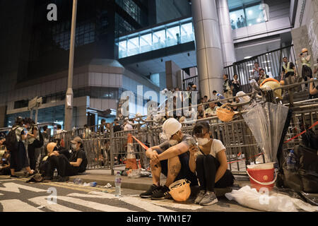 Protesters take a break outside the police headquarters.Hundreds of protesters still blocking assess of the police headquarters of Hong Kong in the early hours of 22 June. Most protester has then left the area at around 3am and police officers has started the cleaning up the area outside the police headquarters. Stock Photo