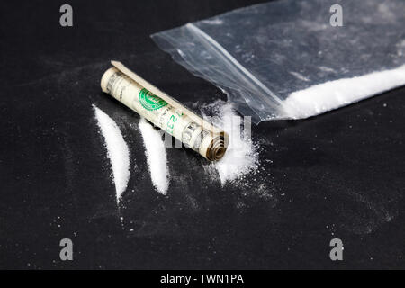 Cocaine stripes. Drug path of cocaine with dollar and bag full of drugs Stock Photo