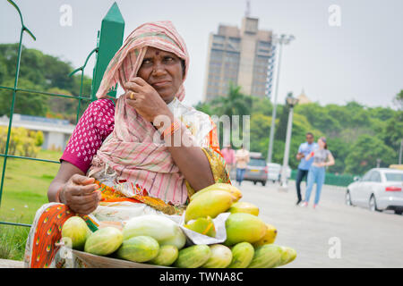 Bangalore, Karnataka India-June 04 2019 :Street vendor Woman selling mango's and cucumber at hot sunny day at Bangalore, India Stock Photo