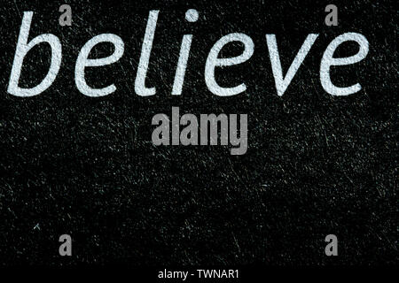 Macro image of the word believe on newsprint in black and white Stock Photo