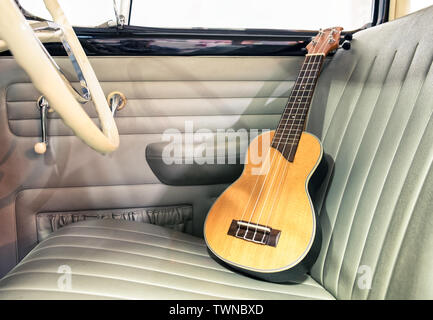 Ukulele wooden on seat vintage car Stock Photo
