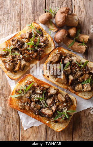 Italian homemade sandwiches with fried boletus mushrooms, onions, thyme and parmesan cheese closeup on the table. Vertical top view from above Stock Photo