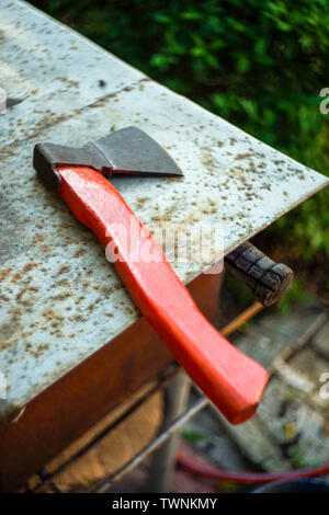 A new ax tool lies on an old rusty table in the garden Stock Photo