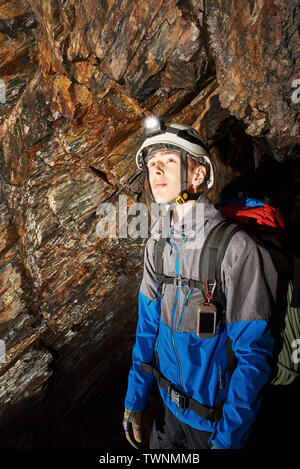 Young speleologist exploring a cave Stock Photo