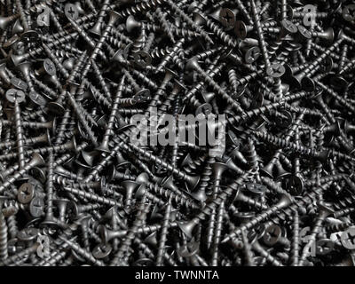Black screws for wood made of steel with cross-shaped grooves on conical head. Stock Photo