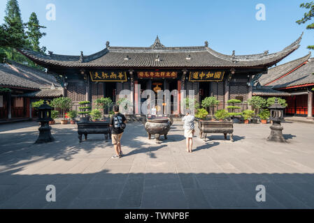 Chengdu, Sichuan Province, China - June 6, 2019 : People praying with burning incense sticks on a sunny day Stock Photo