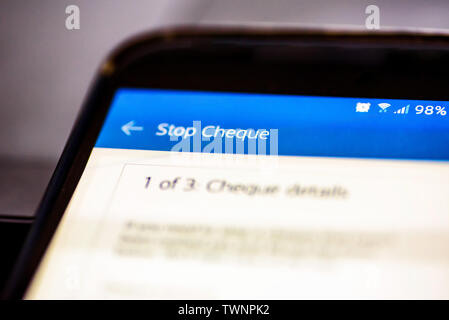 Stop a cheque button on smartphone app screen closeup Stock Photo