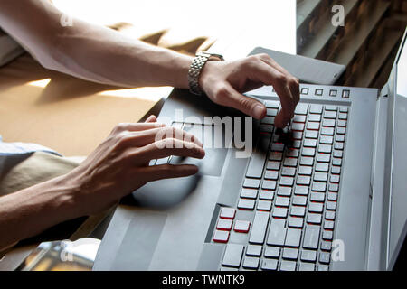 Man working on his laptop with mobile phone Stock Photo