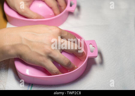 Process paraffin treatment of female hands in beauty salon. Manicure in beauty salon. Selective focus on costumer's nails. Stock Photo