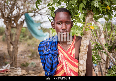 MASAI VILLAGE, KENYA - OCTOBER 11, 2018: Unindentified african boy wearing traditional clothes in Masai tribe, Kenya Stock Photo