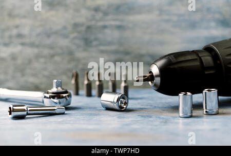 Drill-driver with driver bit on wooden background with copy space. Stock Photo