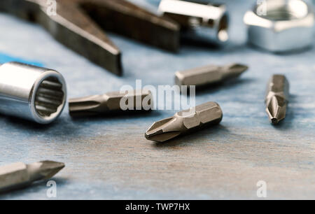 Bits for a screwdriver and socket wrench on wooden background. Close up. Stock Photo