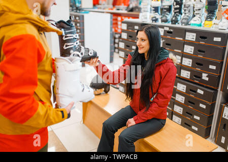 Woman trying on ski or snowboarding boots Stock Photo