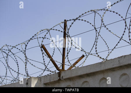 Concrete wall, against the backdrop of barbed wire, the concept of prison, salvation, Refugee, lonely Stock Photo