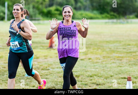 Kings Park, New York, USA - 17 June 2019: Two women smiling ane waving at the camera during the State Parks summer series at Sunken Meadow 10k course. Stock Photo