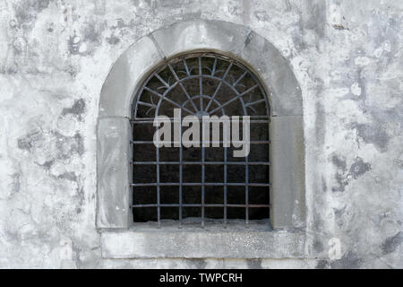 Semicircular lattice window in an old facade Stock Photo