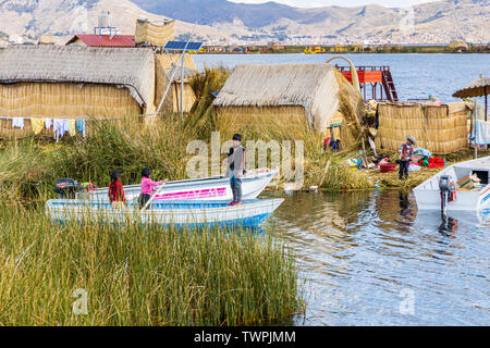 Boating through the reeds and floating villages of Uros islands on Lake Titicaca, Peru, South America Stock Photo