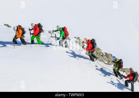 Mountain guide leading a group of alpinists up to Monte Rosa Glaciers at a sunny day in winter Stock Photo