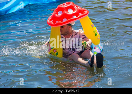 Iford, Dorset, UK. 22nd June 2019. Perfect weather, warm sunny and still, for Dorset Dinghy Day with hundreds of inflatables, dinghies, crafts, boards forming a flotilla, setting sail from Iford bridge down the River Stour to Tuckton bridge. The event started in 2014 as a little bit of fun, but has now become an annual event raising money for charity and getter bigger each year. Man in inflatable mushroom pool. Credit: Carolyn Jenkins/Alamy Live News Stock Photo