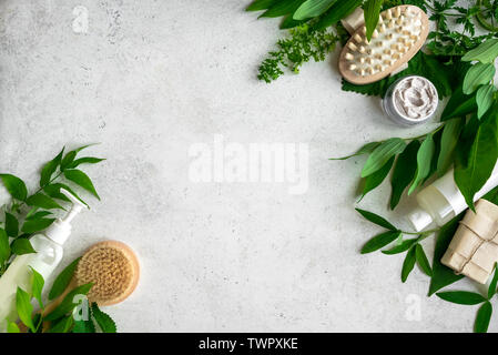 Natural cosmetics and green leaves on white stone background, copy space. Natural organic skincare, bio research and healthy lifestyle concept. Stock Photo