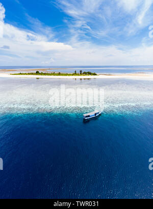 Aerial idyllic atoll, scenic travel destination Maldives Polinesia. Blue lagoon and turquoise coral reef. Shot in Wakatobi National Park, Indonesia Stock Photo