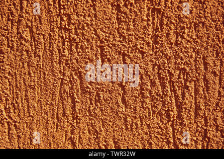 Orange colored wall with rough texture. Stock Photo