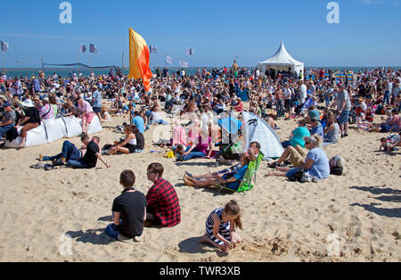 22nd June 2019. Lowestoft, England, UK. Lowestoft's First Light Festival, crowds gather on South Beach with temperatures of over 20 degrees with beautiful blue skies. Festival runs for 24 hours non-stop until 12 pm on Sunday. Visitors look at the straw Pakefield Man'. Arts charity FlipSide are delivering the festival in partnership with Hemingway Design. Visitors look at the straw Pakefield Man'. Stock Photo