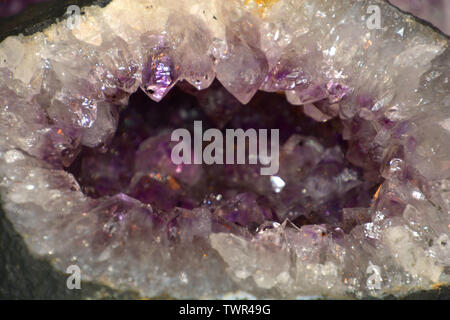amethyst geode natural crystal gemstone macro shot purple background with bokeh effect, amethyst quartz in silver and purple Stock Photo