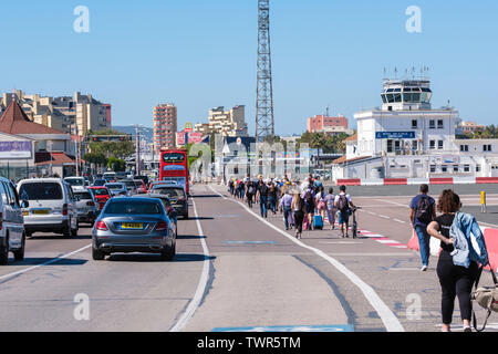 Gibraltar International Airport, main road that crosses runway re-opened after closure for aircraft activity, so pedestrians & vehicles surge over Stock Photo