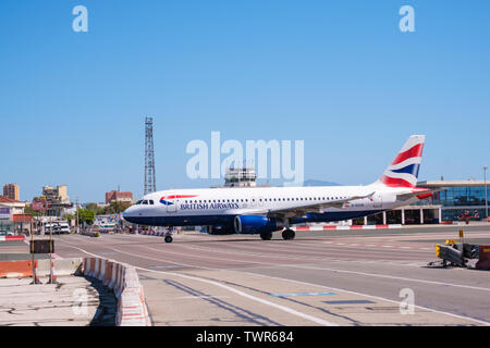 Gibraltar International Airport with British Airways flight crossing the closed main road as it is taxiing out take off for London Stock Photo